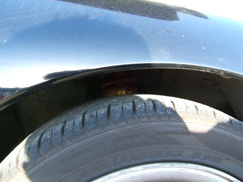 1996 Ford Probe - A close-up shot of a car's wheel well, revealing the tire and part of the suspension system.