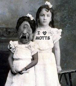 2002 Ford Crown Victoria - A vintage photograph shows two young girls posing, with one wearing a striking cyclops monster mask. Text overlays include 'I LOVE MOTTS' a…