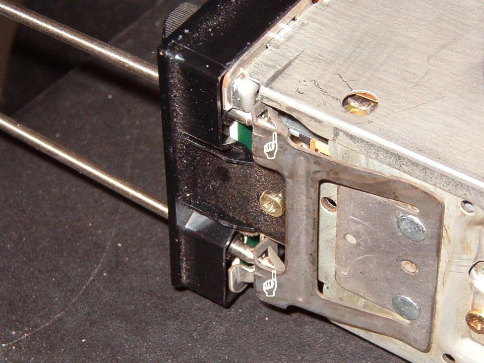 As the tool is inserted, the tapered tip rides up the ramp of the clip, compressing the spring & drawing the catch inward.