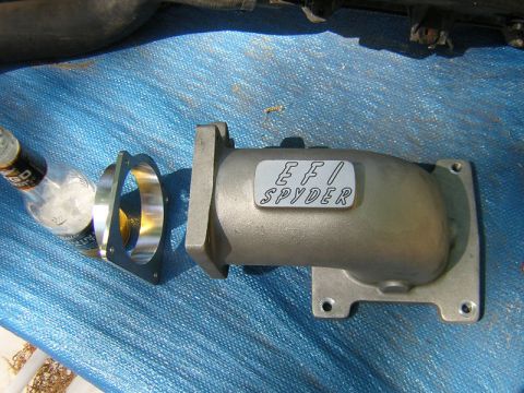 1979 Ford Bronco - Aftermarket EFI SPYDER intake manifold and adapter plate shown on a blue tarp.