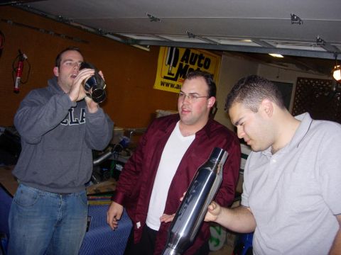 1998 Ford Crown Victoria - Friends inspect a car exhaust pipe in a garage setting.