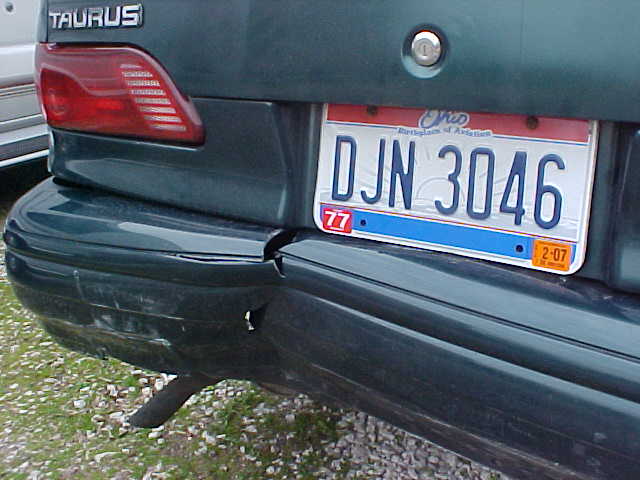 Rear bumper of a green Ford Taurus with dented corner and Ohio plate DJN 3046