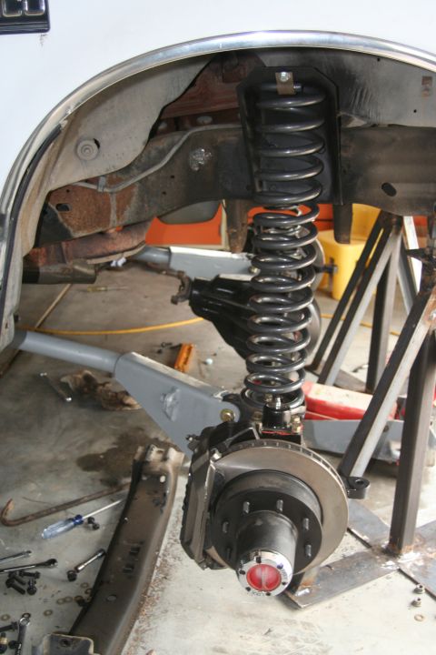 1992 Ford Bronco - Close-up of a vehicle's front suspension and brake system, showing the coil spring and brake rotor.