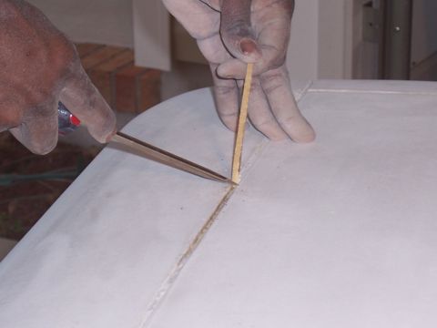 1978 Ford Bronco - Close-up of a person performing fiberglass repair work on a white surface.