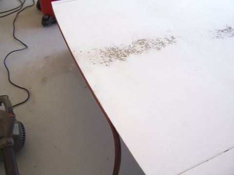 1978 Ford Bronco - A white fiberglass panel shows areas of rust and wear, with a leaf blower nearby.