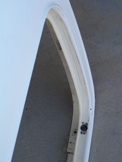 1978 Ford Bronco - A close-up view of a white fiberglass automotive part, possibly a roof section, with mounting holes.