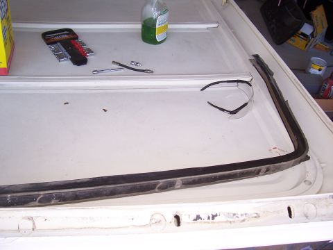 1978 Ford Bronco - Fiberglass top removed from a Ford Bronco, revealing the frame and weatherstripping, with tools nearby.