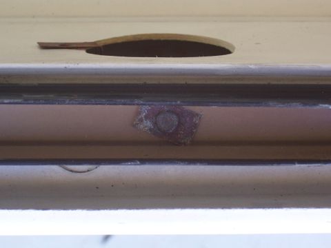 1978 Ford Bronco - A close-up view of a metal clip and an oval-shaped cutout on a vehicle's interior trim panel.