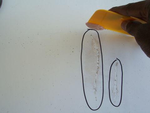1978 Ford Bronco - Close-up of two cracks in fiberglass being repaired, with a yellow applicator tool.