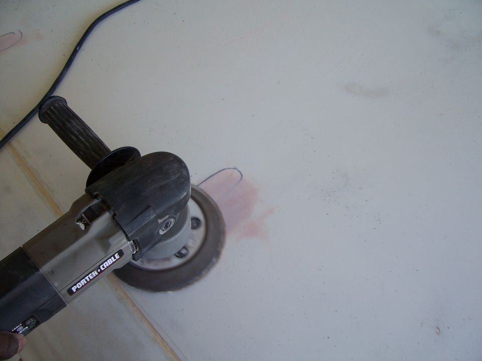 Angle grinder with a Porter-Cable label is sanding a light-colored surface, creating a pink dust cloud