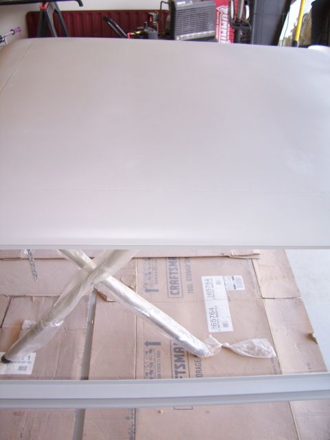 1978 Ford Bronco - Fiberglass top for a Ford Bronco, stored indoors on boxes with protective wrapping on metal bars.