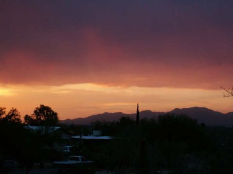 1995 Ford Probe - A white pickup truck is visible in silhouette during a colorful sunset over a residential area with mountains in the background.