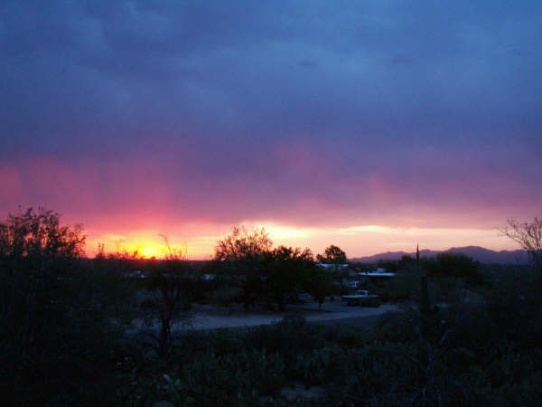 Sunset over desert with truck; SUPERMOTORS.NET text
