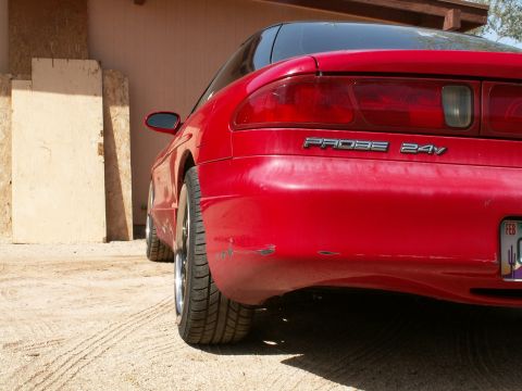 1995 Ford Probe - Rear view of a red 1995 Ford Probe, showing the 'PROBE 24V' badging and some damage.