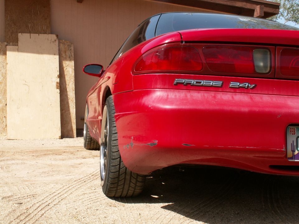 1995 Ford Probe rear bumper with 'PROBE 24V' badge and scuffs. License plate visible