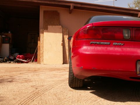 1995 Ford Probe - The rear of a red 1995 Ford Probe is visible, with 'PROBE 24V' badging on the trunk.