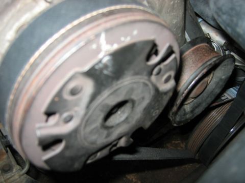 1985 Ford LTD Crown Victoria - This image shows a close-up view of a vehicle's engine belt and a tensioner pulley assembly.