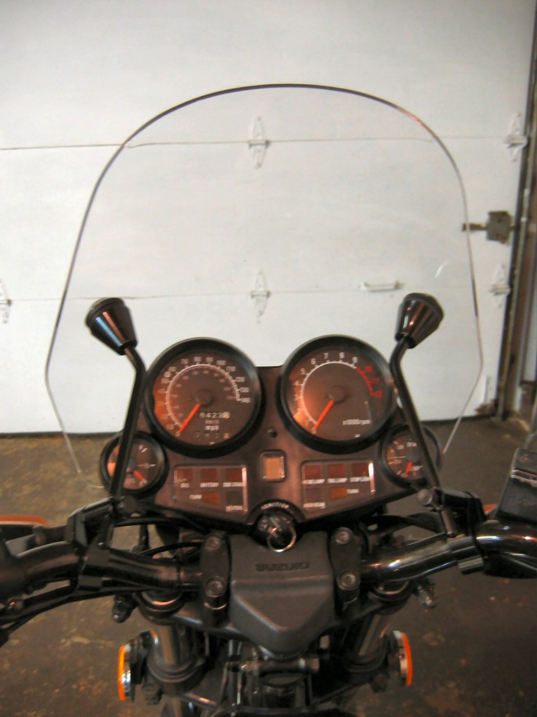 Motorcycle dashboard with dual gauges, windscreen, and Suzuki logo