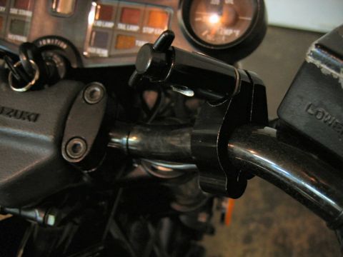 1985 Ford LTD Crown Victoria - Close-up view of motorcycle handlebars, the ignition switch, various indicator lights, and gauges, with "SUZUKI" branding visible.