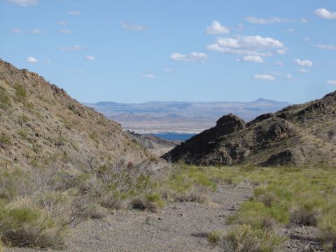 1996 Ford Bronco - A scenic view of a desert landscape, mountains and a distant body of water under a partly cloudy sky.