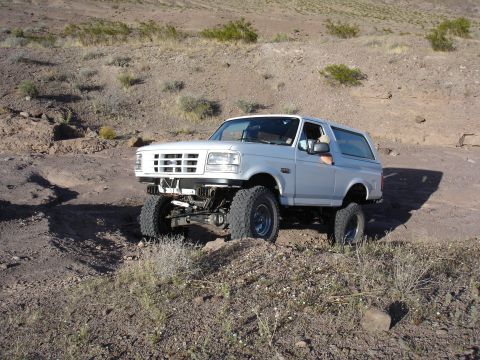1996 Ford Bronco - A lifted 1996 Ford Bronco navigates a rocky, arid terrain.
