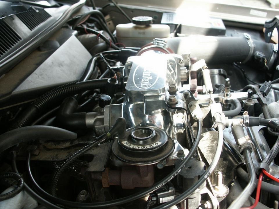 Polished aftermarket throttle body and EGR valve on a fuel-injected V8 engine