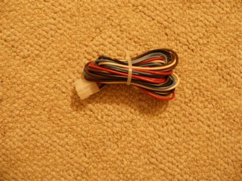1978 Ford F-150 - Wiring harness with multiple colored wires and a white connector, lying on a carpet.