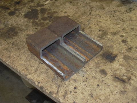 1991 Ford Bronco - A fabricated metal part, possibly a crossmember, is shown on a workbench.