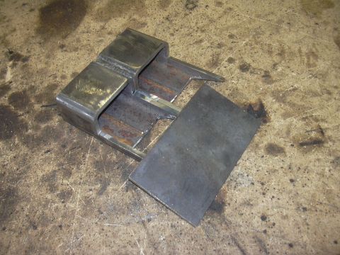 1991 Ford Bronco - A fabricated metal component sits on a worn, stained surface.