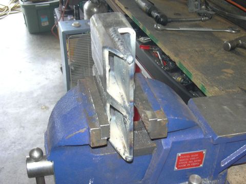 1991 Ford Bronco - A metal component is secured in a vise, ready for work, with workshop items visible.