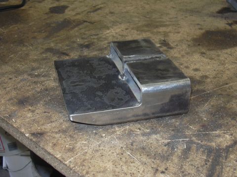 1991 Ford Bronco - A fabricated metal bracket sits on a worn workbench surface.