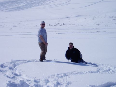 2000 Ford E350 - Two men are in a vast snowy landscape, with tracks visible in the background.