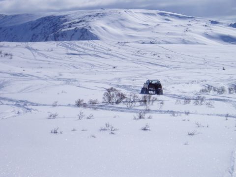 2000 Ford E350 - A vehicle navigates a snow-covered terrain with rolling hills in the background.