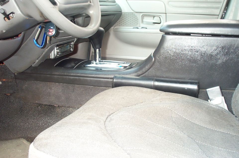 Sedan interior with floor-shift center console, chrome automatic shifter, and gray cloth seat