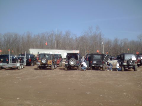 1991 Ford Bronco - A group of Jeep Wranglers are gathered in an outdoor lot under a clear blue sky.