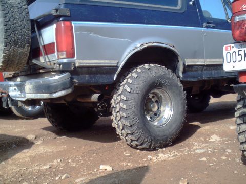 1991 Ford Bronco - This SUV features large off-road tires and a spare tire mounted on the rear, suggesting it is built for terrain.