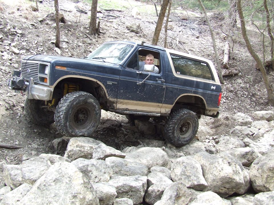 Dark blue 1986 Ford Bronco navigating a rocky trail