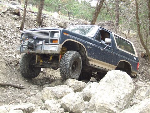 1986 Ford Bronco - This Ford Bronco is navigating a rocky trail, showing off its off-road capabilities.