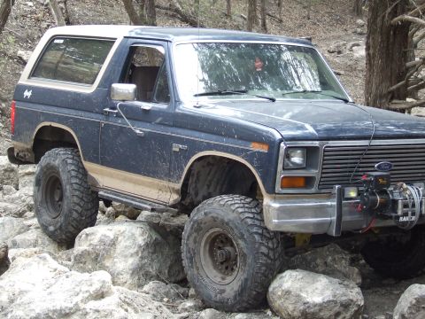 1986 Ford Bronco - This Ford Bronco navigates a challenging rocky trail, its off-road capabilities.