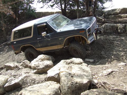 1986 Ford Bronco - This Ford Bronco appears to be from the early 1980s, not 1986, as it navigates a challenging rocky terrain.
