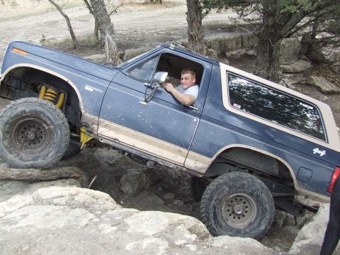 1986 Ford Bronco - This modified Ford Bronco navigates a challenging rocky terrain, demonstrating its off-road capabilities.