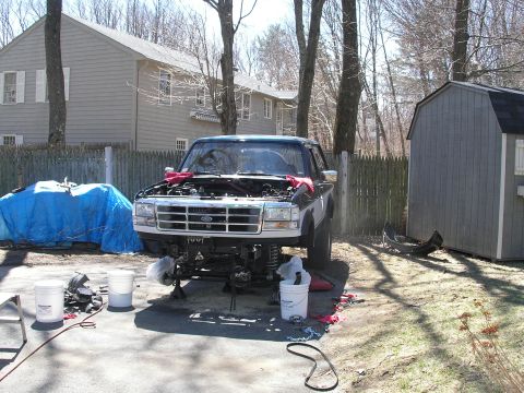 1994 Ford Bronco - Ford Bronco undergoing front-end repair in a residential driveway.