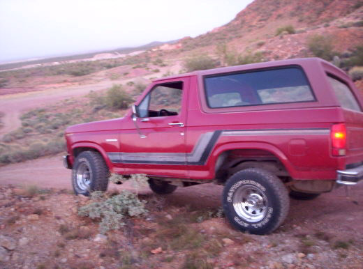 red SUV on a dirt road with hills in the background