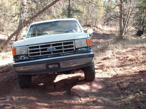 1988 Ford Bronco - White 1987 Ford Bronco navigating a rocky off-road trail.