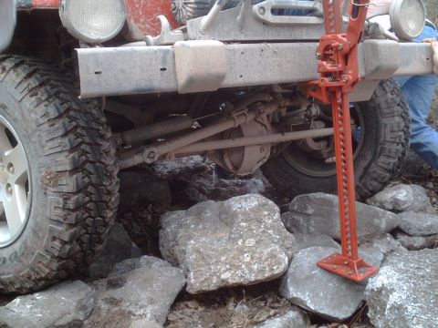 1991 Ford Bronco - A vehicle is being lifted by a Hi-Lift jack while navigating rocky terrain.