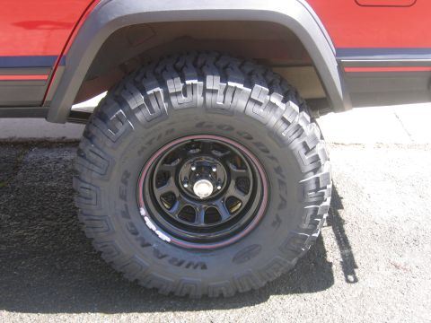 1996 Jeep Cherokee - Close-up of a lifted 1996 Jeep Cherokee's off-road tire and suspension system.
