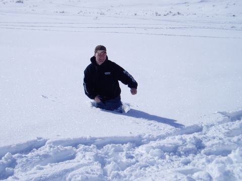 2000 Ford E350 - A man is stuck in a snowy field, with tire tracks visible in the foreground.