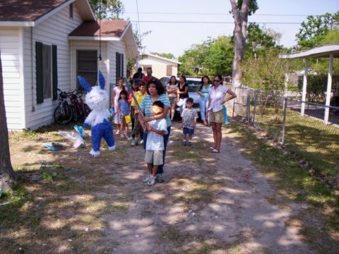 1986 Ford Bronco - A group of people, including children, are gathered for a pi 0 0ata breaking event in a residential yard.