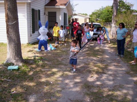 1986 Ford Bronco - A group of people, mostly children, are gathered for a piñata party outdoors.