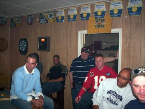 1986 Ford Bronco - A group of men are seen in a room with various decorations, including beer advertisements and sports team banners.
